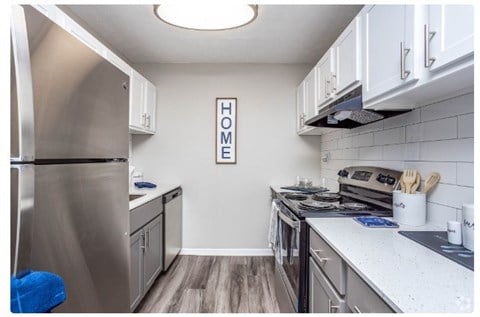 a kitchen with stainless steel appliances and white cabinets